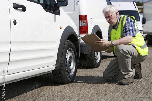 Photo: Man checking the condition of vehicle Man checking the condition of vehicle