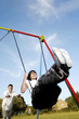 Foto: Father pushing daughter on swing Father pushing daughter on swing