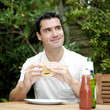 Photo: Man thinking while holding a burger Man thinking while holding a burger