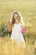 Girl blowing bubbles in the field