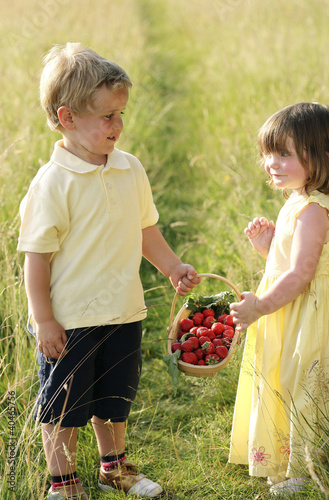 Foto: Children holding a basket of strawberries Children holding a basket of strawberries