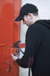 Burglar breaking lock with hammer