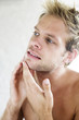 Man checking his face in the mirror