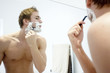Bare chested man shaving
