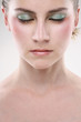 Woman with sparkling eyeshadow closing her eyes