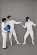 Businesswoman holding a mobile phone for a man while he stops the fencing competition