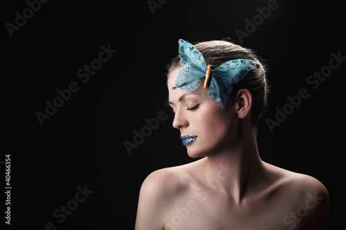 Photo: Woman with rhinestones on her lips and butterfly decorating her hair Woman with rhinestones on her lips and butterfly decorating her hair