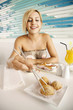 Woman reaching for fried yam puff with chopsticks