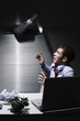 Terrified businessman looking at hand with knife coming out from window blinds