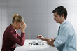 Businessman and businesswoman playing chess game