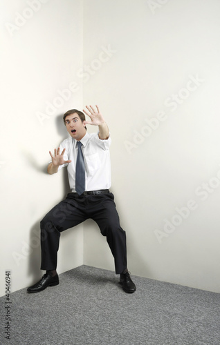 Photo: Businessman raising arms to shield himself Businessman raising arms to shield himself