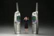 Businesswoman standing in between two ringing phones