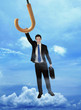 Businessman holding on to a flying umbrella