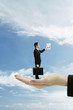 Businessman standing on a giant palm