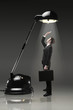 Businessman standing under an illuminating table lamp