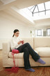 Woman sitting on couch knitting