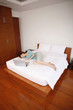 Woman lying in bed with her eyes closed, laptop beside her
