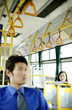 Businesswoman looking at a businessman while sitting in a bus