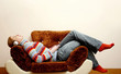 Teenage girl sleeping on the couch listening to music on the headphones