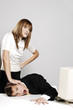 Businesswoman pressing her colleague's head against the table