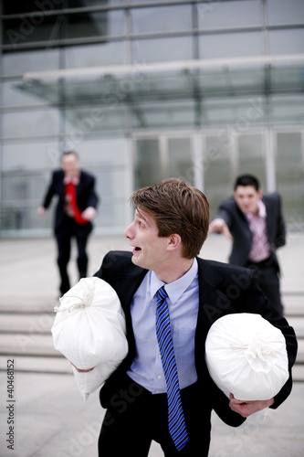 Photo: Businessman running after stealing two bags of money Businessman running after stealing two bags of money
