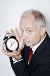 Businessman holding an alarm clock