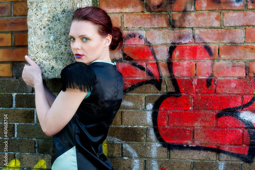Photo: Pretty young female against grafitti wall Pretty young female against grafitti wall
