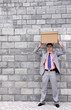 Businessman putting a box on top of his head