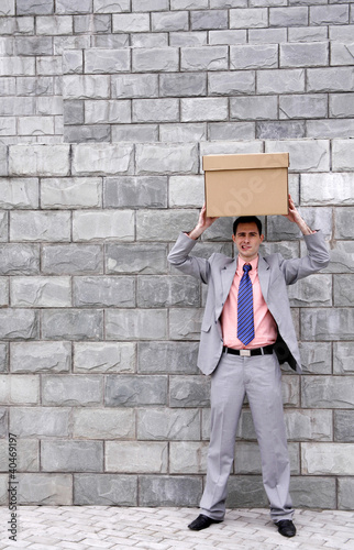 Foto: Businessman putting a box on top of his head Businessman putting a box on top of his head