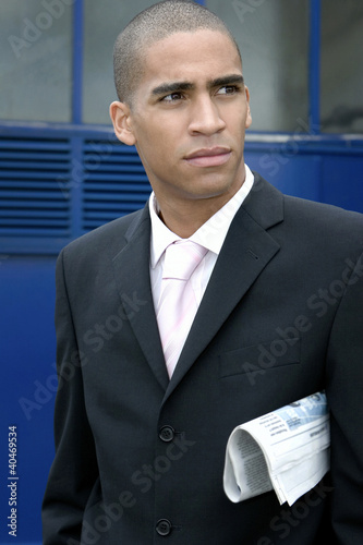Photo: Businessman with a folded newspaper under his arm Businessman with a folded newspaper under his arm