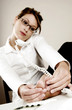Businesswoman checking her toes while talking on the phone