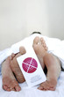 Couple on the bed with a sign hanging from the toe