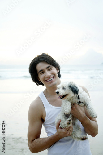 Foto: Man posing with his dog on the beach Man posing with his dog on the beach