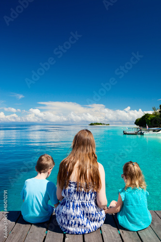 Foto: Mother and kids sitting on wooden dock Mother and kids sitting on wooden dock