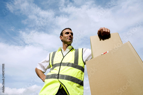 Photo: Low angle view of a delivery man beside some boxes Low angle view of a delivery man beside some boxes