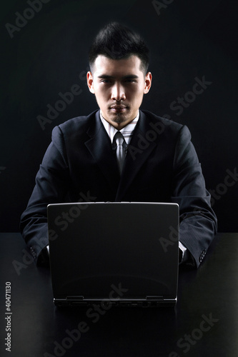 Photo: Businessman sitting at the table using laptop Businessman sitting at the table using laptop