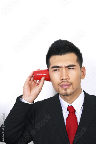 Photo: Businessman playing with plastic cup phone Businessman playing with plastic cup phone