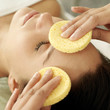 Hand wiping a woman's face with sponge