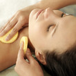 Hand wiping a woman's neck with sponge