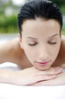 Woman lying forward on massage table with her eyes closed