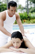 Woman getting a body massage at the pool side