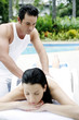 Woman getting a body massage at the pool side