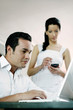 Man using laptop while his girlfriend is using palmtop