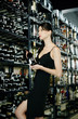 Woman choosing wine in a wine cellar