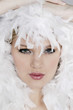 Young woman with white feathers posing for the camera