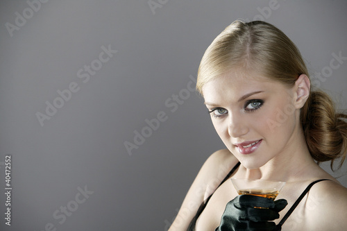 Photo: Young woman holding a glass of champagne Young woman holding a glass of champagne