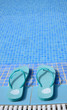 Turquoise flip flops near the tropical swimming pool