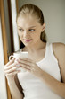 Foto: Young woman holding a cup of coffee Young woman holding a cup of coffee