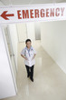 Female doctor standing under an emergency sign