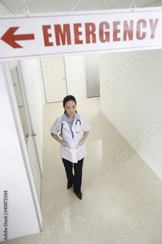 Foto: Female doctor standing under an emergency sign Female doctor standing under an emergency sign